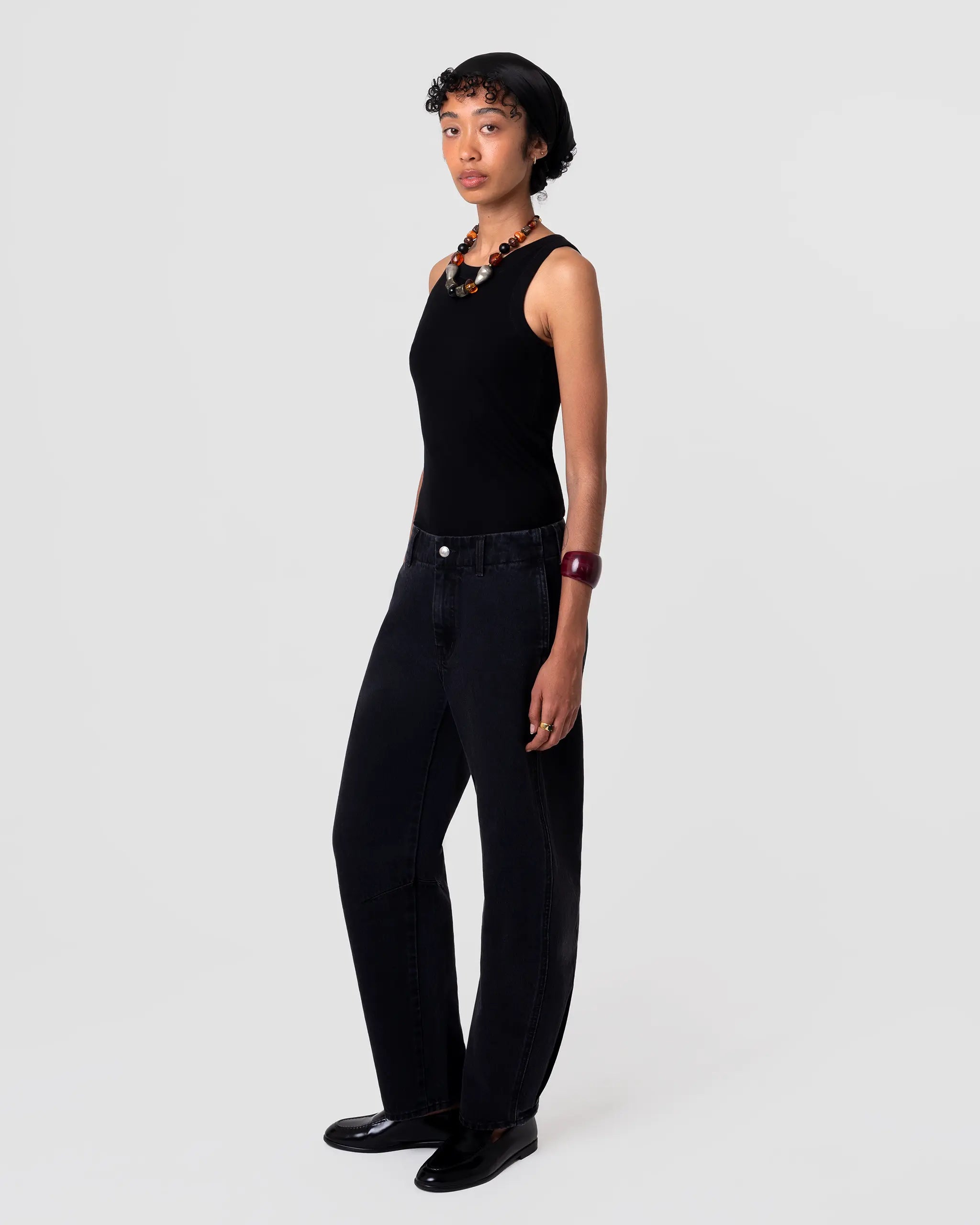 Cut 103 Barrel Jean in black denim, sculpted barrel leg silhouette, structured drape, high rise, subtle matte finish; full-length view. Pleated hem detail at cuff adds volume.